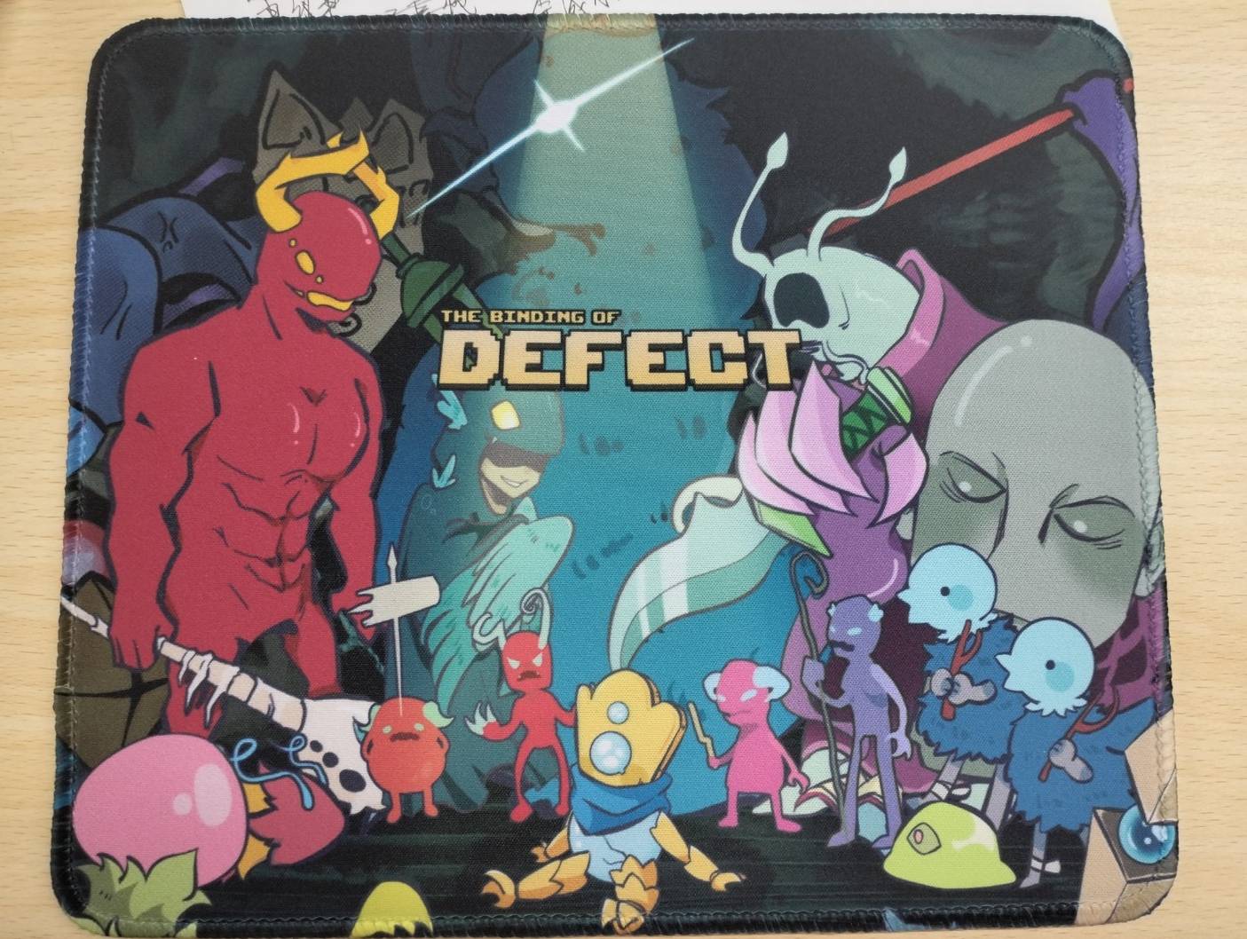A mousepad featuring an illustration of Slay the Spire characters in the style of Binding of Isaac.