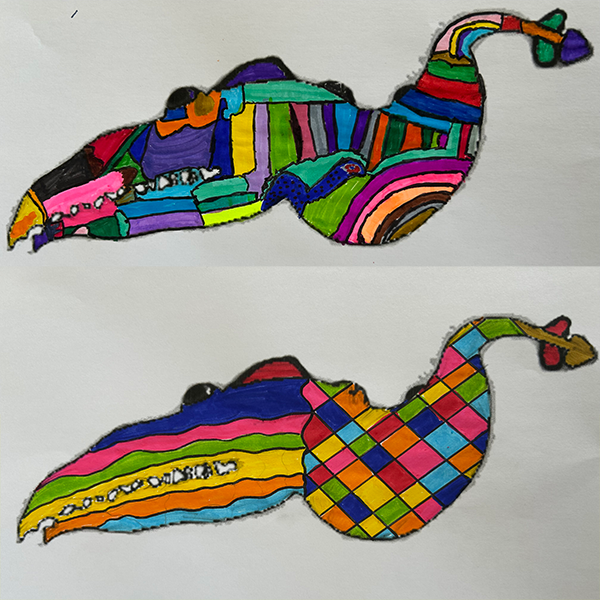 Multi-colored drawings of the mystery creature on paper.